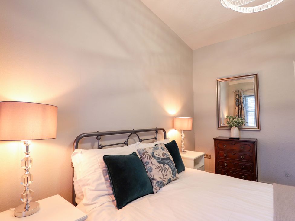 A bedroom with a bed and lamps at Porter's Lodge in Inverness