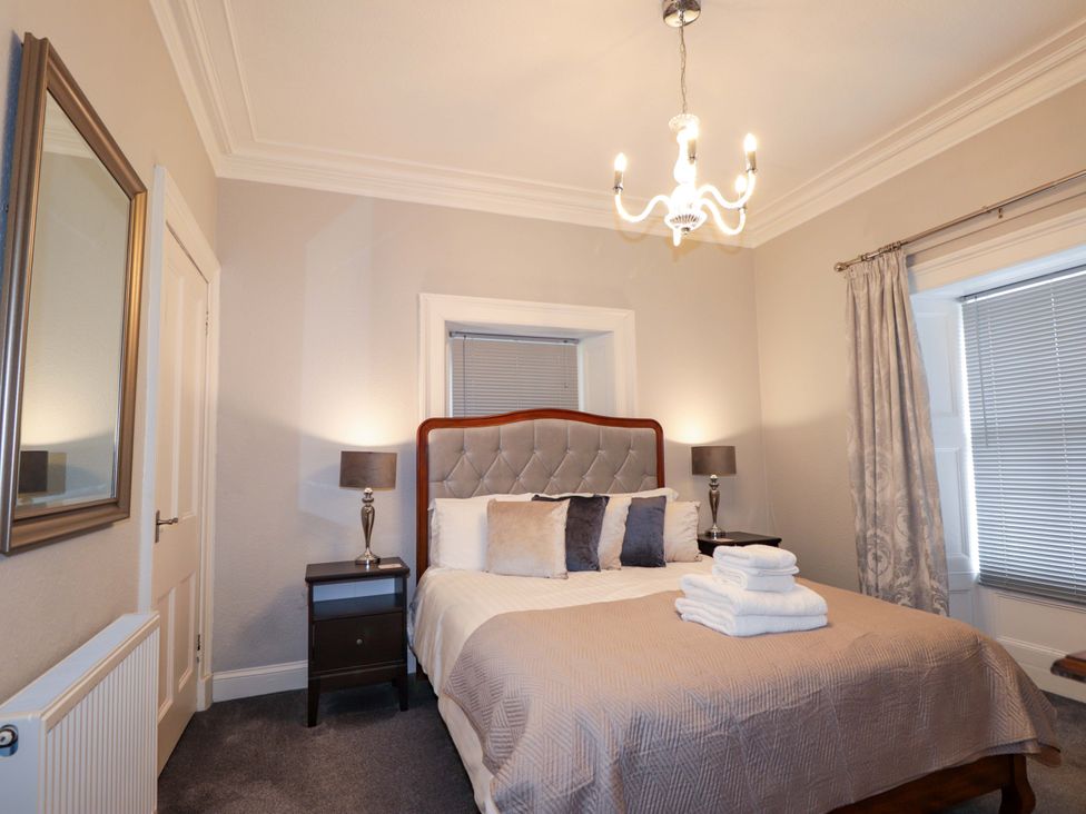A bedroom with a bed and nightstand at Porter's Lodge in Inverness
