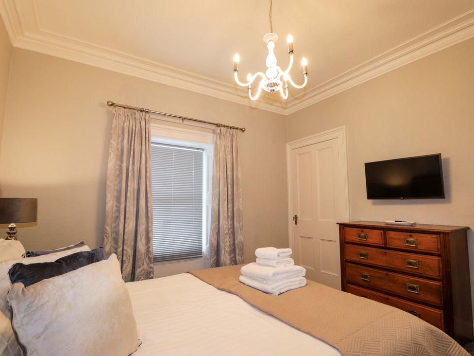 A bedroom with a bed and a TV at Porter's Lodge in Inverness