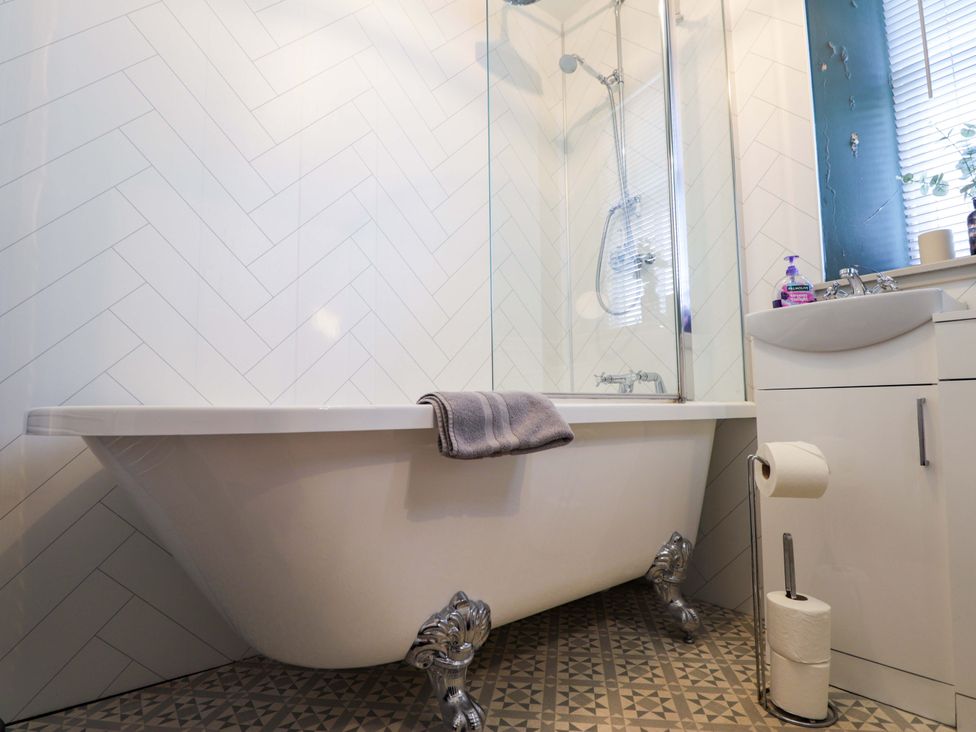 A bathroom with a bath tub and sink at Porter's Lodge in Inverness