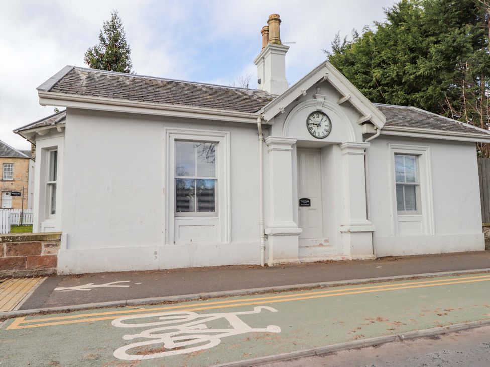 An exterior view of a building featuring a clock and windows at Porter's Lodge in Inverness