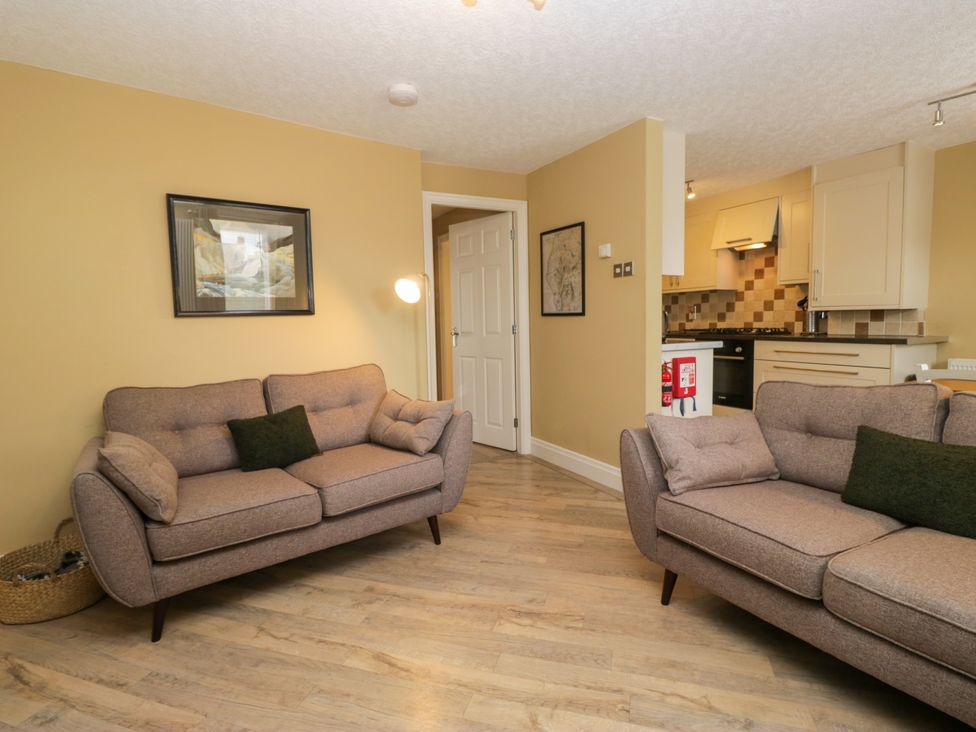 A living room with two sofas and a kitchen area at Jenny's in Hawkshead