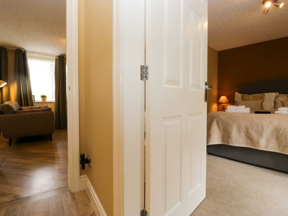 A bedroom with a door open to a living area at Jenny's in Hawkshead