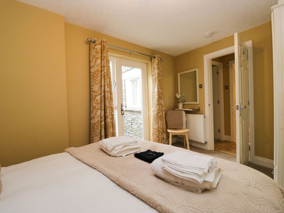 A bedroom with a bed and towels at Jenny's in Hawkshead