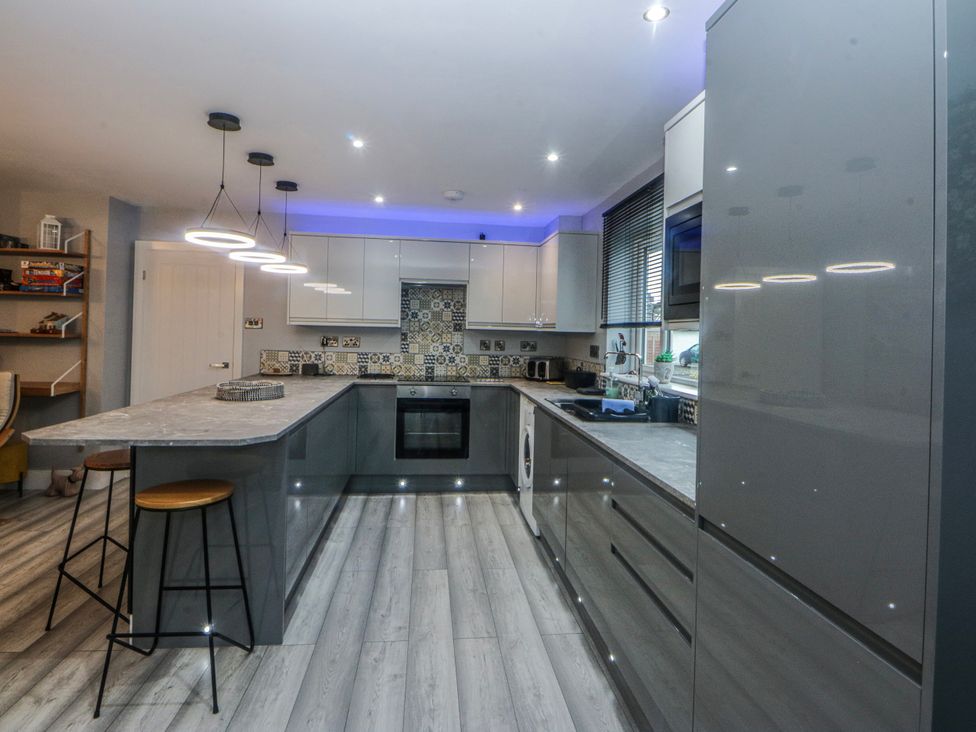 A kitchen with cabinets and appliances at Ty Glan Morfa in Morfa Bychan