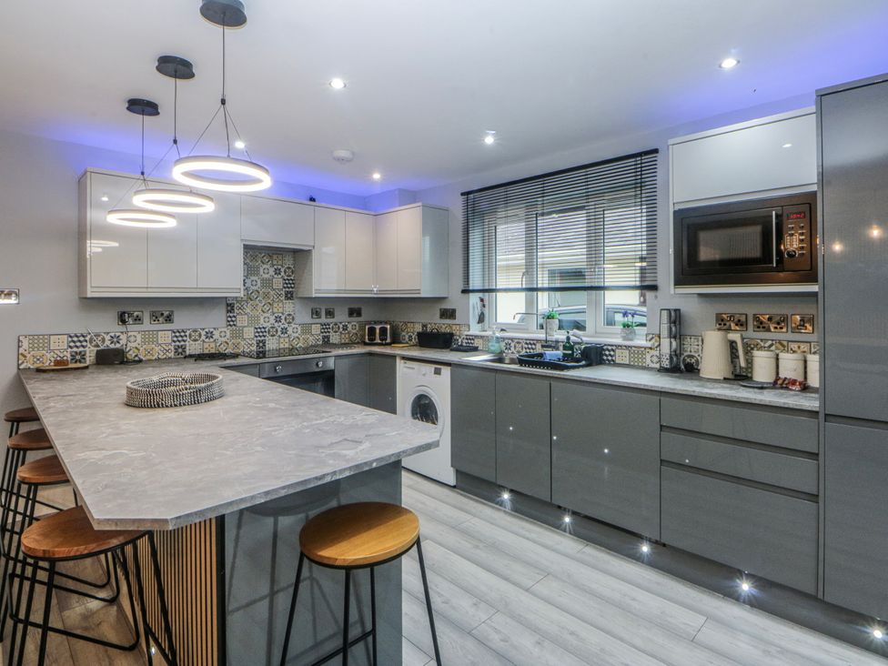 A kitchen with modern cabinets and appliances at Ty Glan Morfa in Morfa Bychan