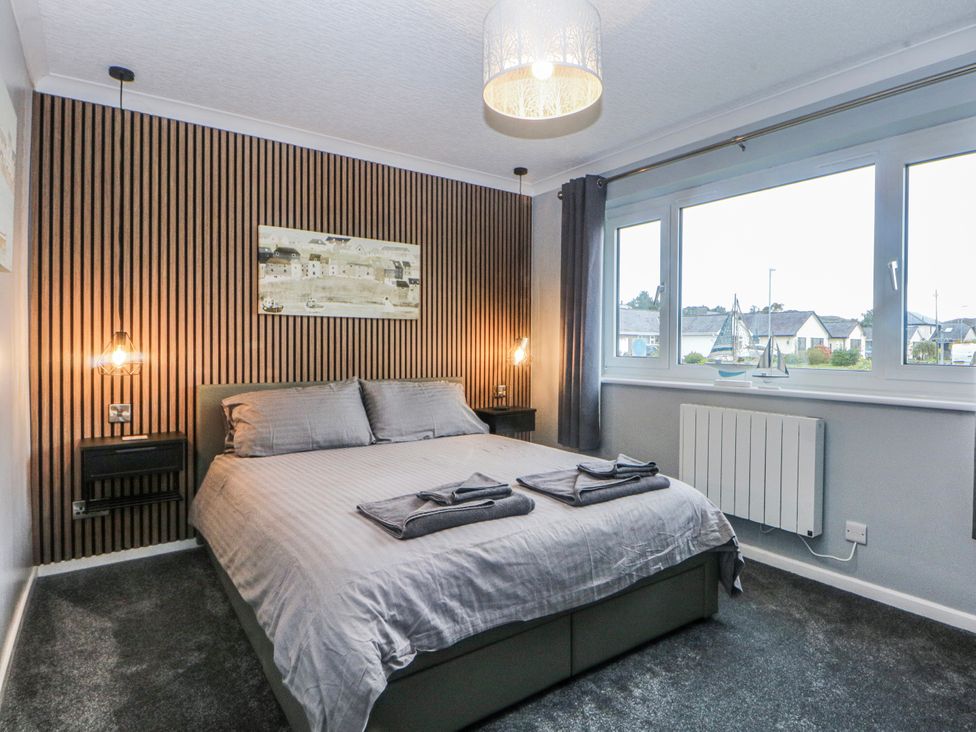 A bedroom with a bed and a window at Ty Glan Morfa in Morfa Bychan