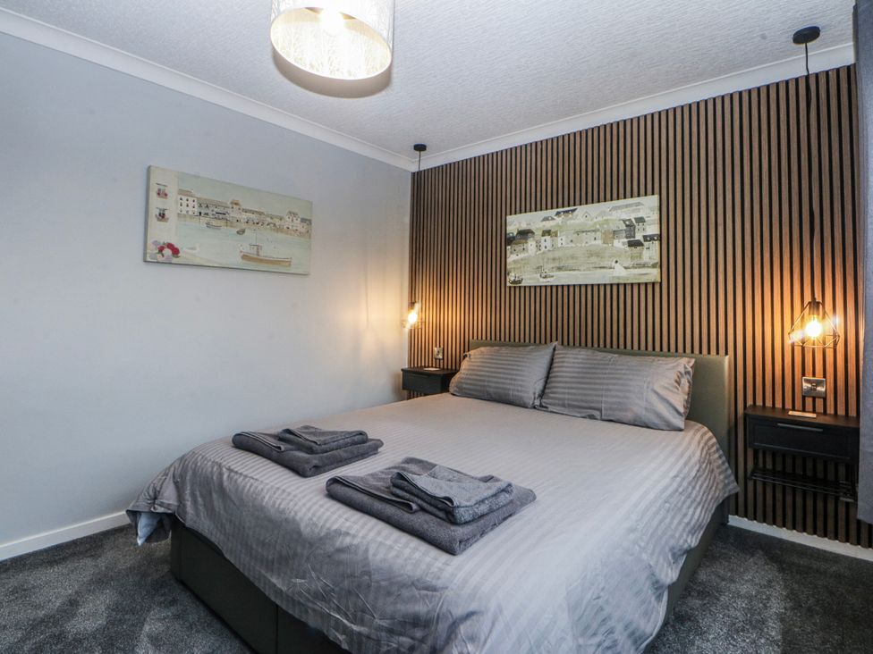 A bedroom with a bed and wall art at Ty Glan Morfa in Morfa Bychan