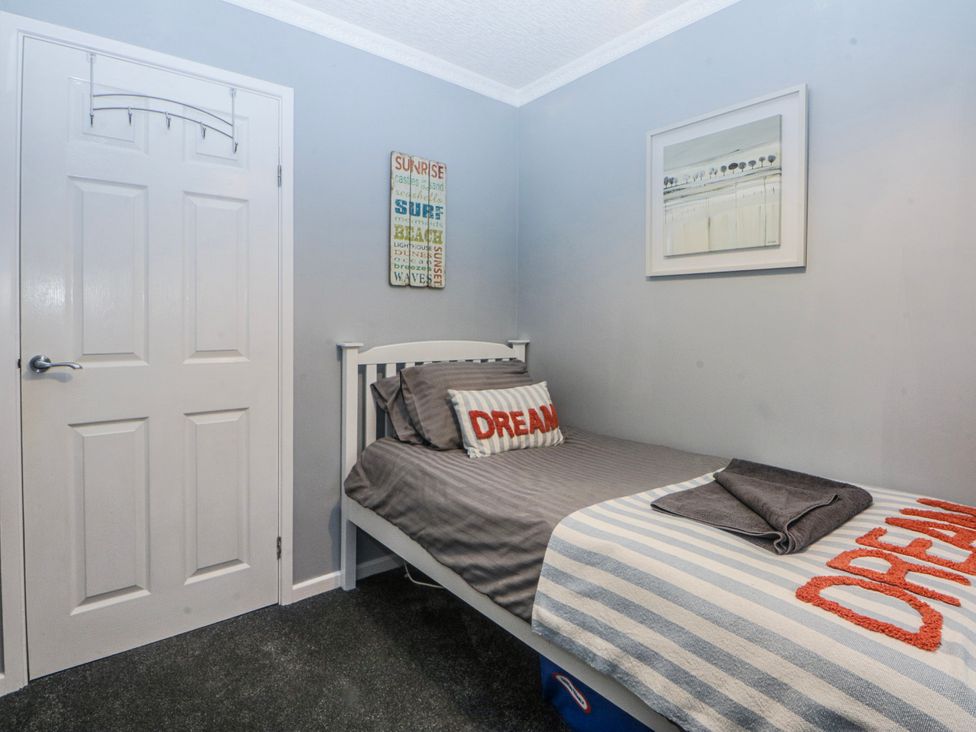 A bedroom with a bed and decor at Ty Glan Morfa in Morfa Bychan