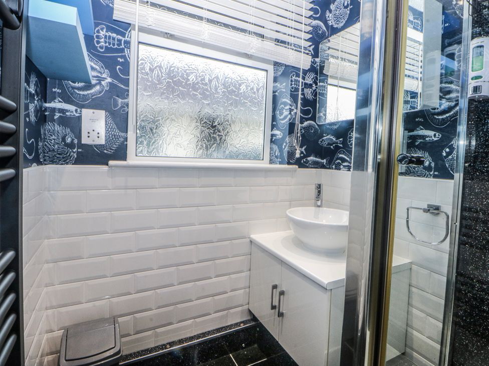 A bathroom with a shower, sink, and toilet at Ty Glan Morfa in Morfa Bychan