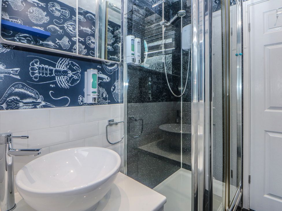 A bathroom with a shower and sink at Ty Glan Morfa in Morfa Bychan
