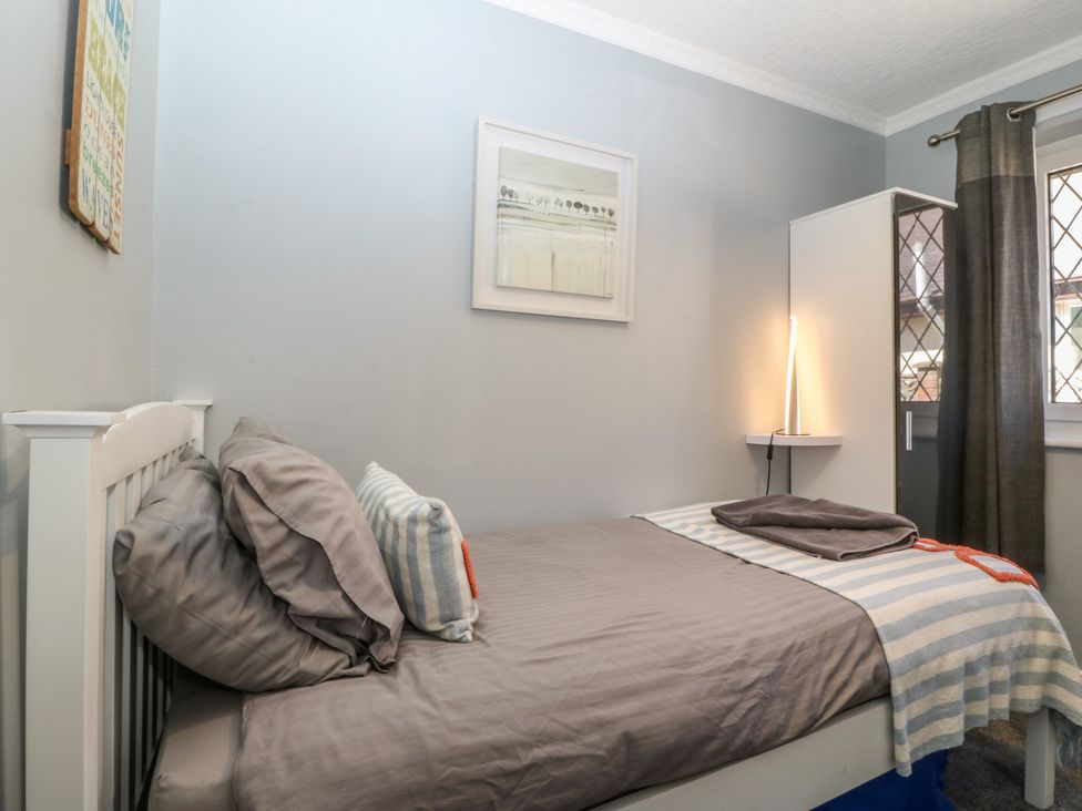 A bedroom with a bed and wardrobe at Ty Glan Morfa in Morfa Bychan