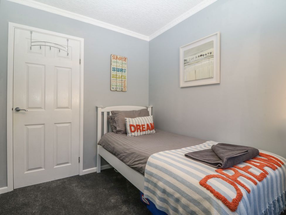 A bedroom with a bed and wall art at Ty Glan Morfa in Morfa Bychan