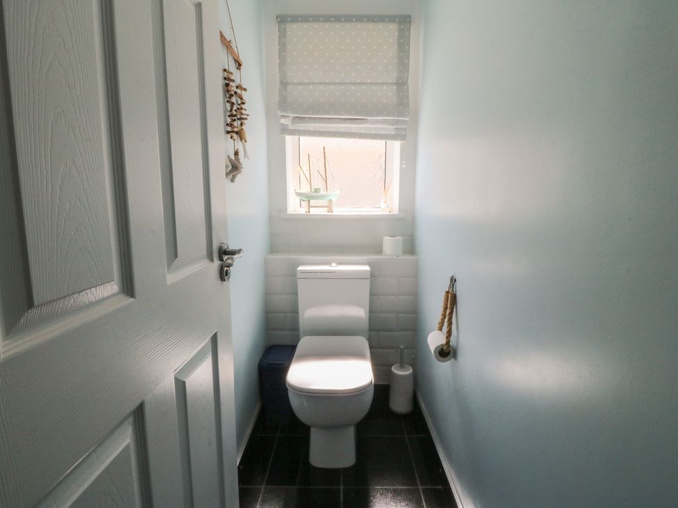 A bathroom with a toilet and sink at Ty Glan Morfa in Morfa Bychan