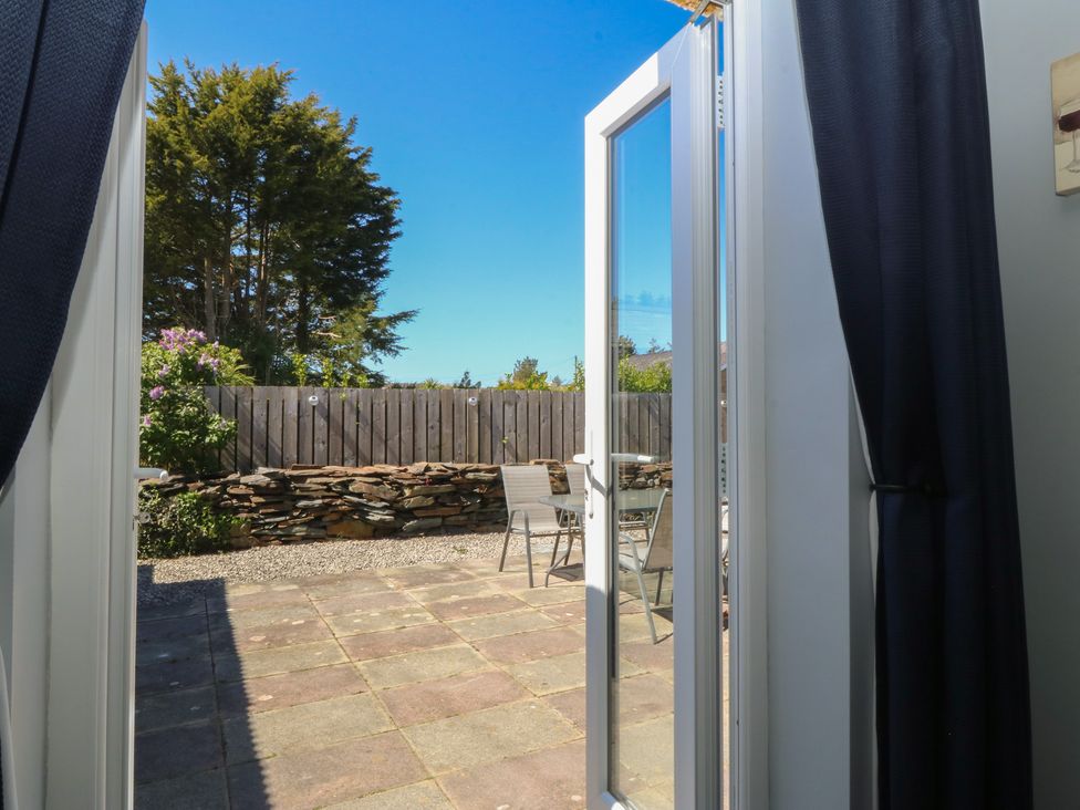 A patio area with a table and chairs at Ty Glan Morfa in Morfa Bychan
