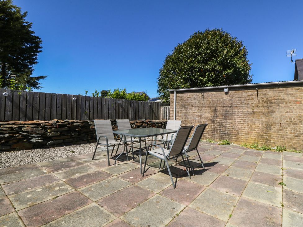 A garden with a table and chairs at Ty Glan Morfa in Morfa Bychan