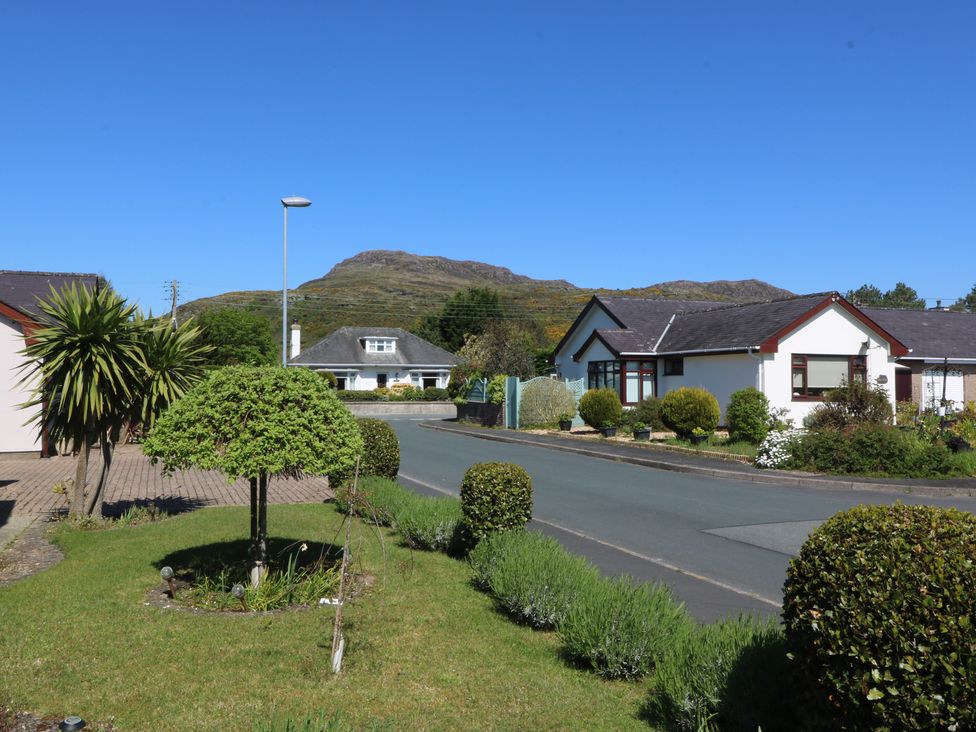 Houses along a road with a mountain in the background at Ty Glan Morfa, Morfa Bychan