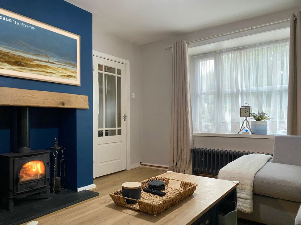 A living room with a fireplace and a TV at Waterfall Cottage in Dyserth