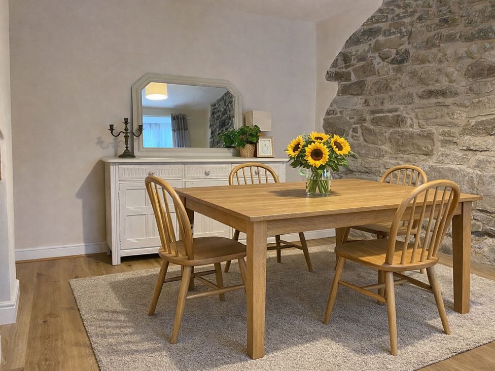 A dining room with a table and chairs at Waterfall Cottage in Dyserth