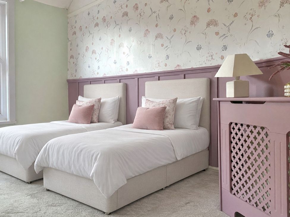 A bedroom with two beds and a lamp at Waterfall Cottage in Dyserth