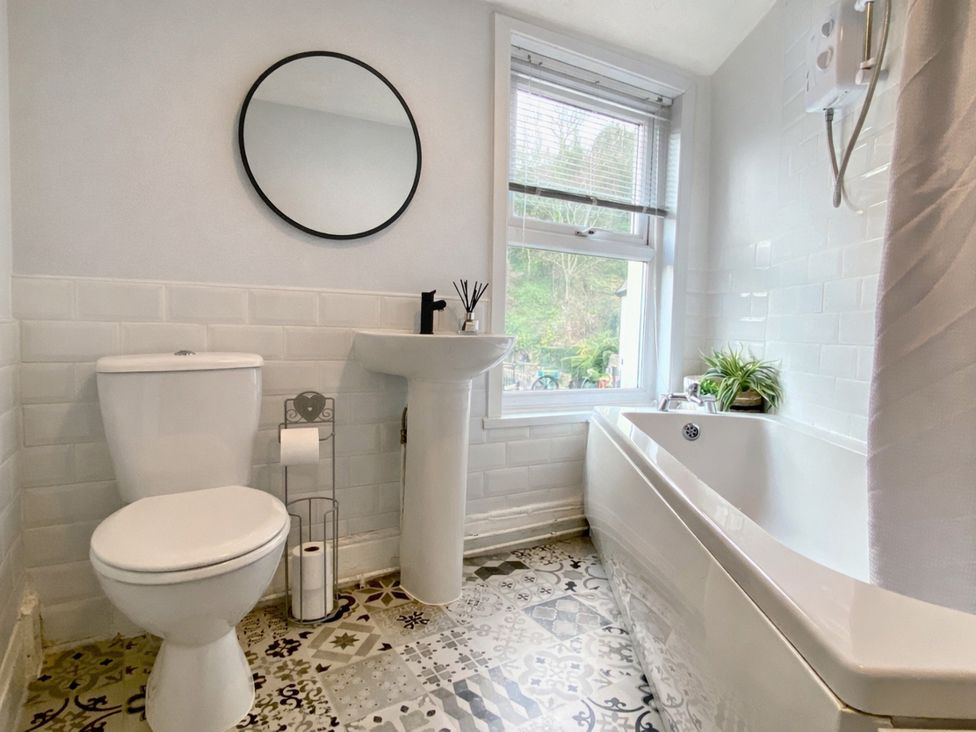 A bathroom with a toilet, sink, and bathtub at Waterfall Cottage in Dyserth