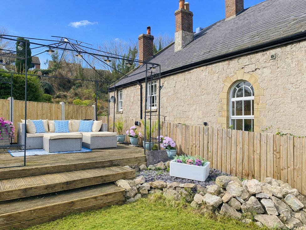 A garden with a couch and canopy at Waterfall Cottage in Dyserth