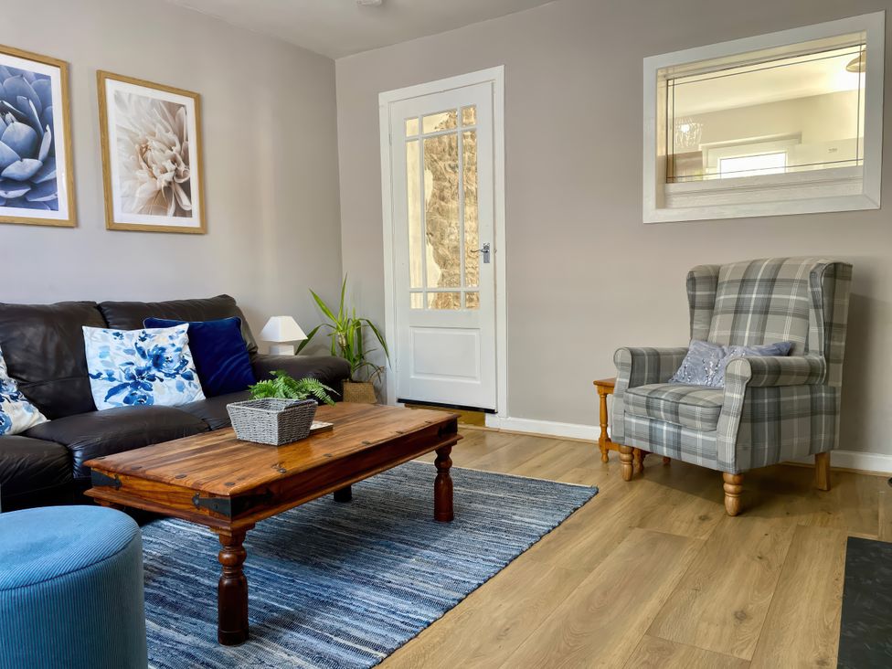 A living room with a sofa and coffee table at Waterfall Cottage in Dyserth