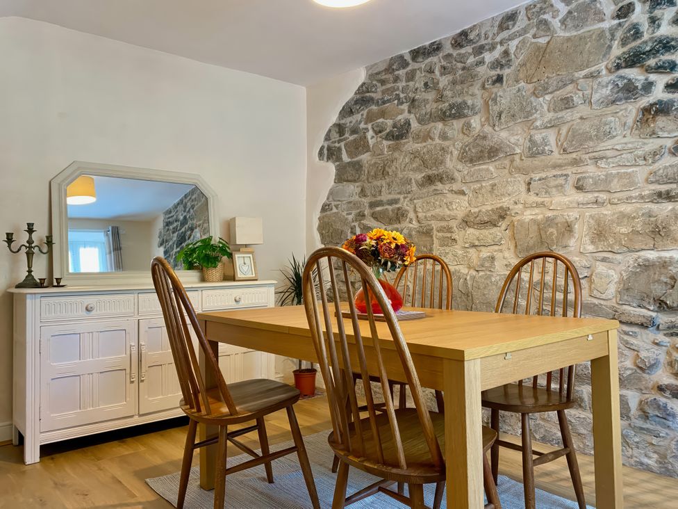 A dining room with a table and chairs at Waterfall Cottage in Dyserth