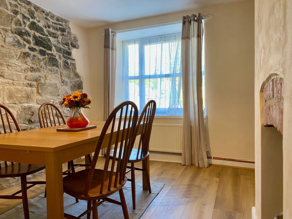 A dining room with a table and chairs at Waterfall Cottage in Dyserth