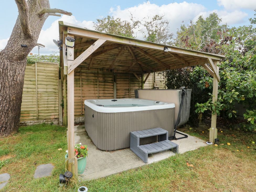 A garden with a hot tub under a canopy at Valley Pines in Valley