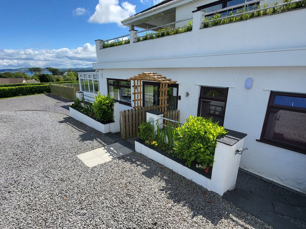 A garden area with plants and gravel path at Top Of The Lane Luxury Holiday Apartment in Benllech