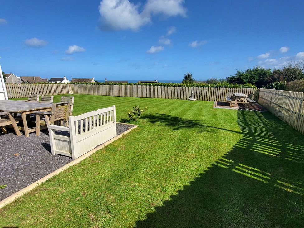 A garden with a table and chairs at Top Of The Lane Luxury Holiday Apartment in Benllech