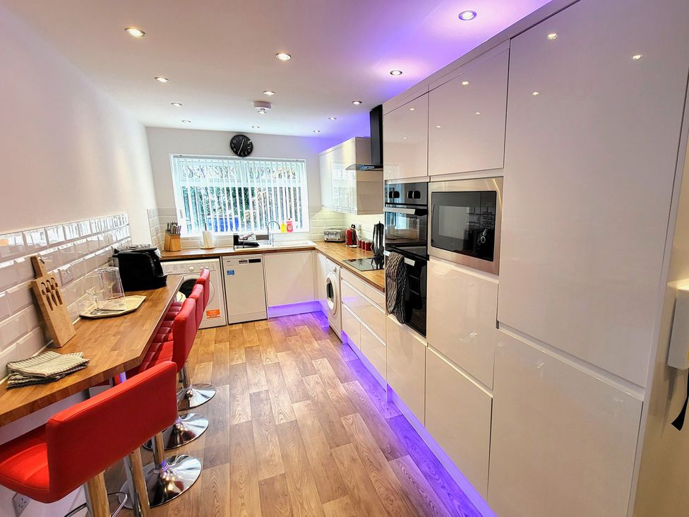 A kitchen with cabinets and a sink at Top Of The Lane Luxury Holiday Apartment in Benllech