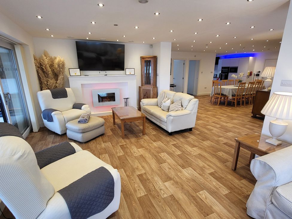 A living room with a coffee table and television at Top Of The Lane Luxury Holiday Apartment in Benllech