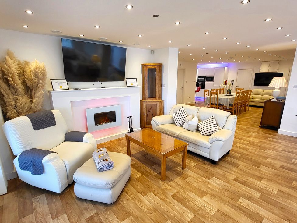A living room with a sofa and armchair in Top Of The Lane Luxury Holiday Apartment in Benllech