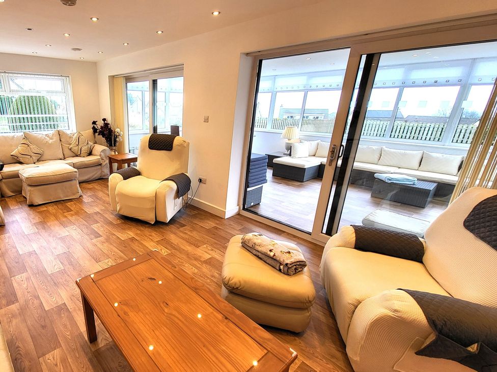 A living room with a sofa and armchair at Top Of The Lane Luxury Holiday Apartment Benllech