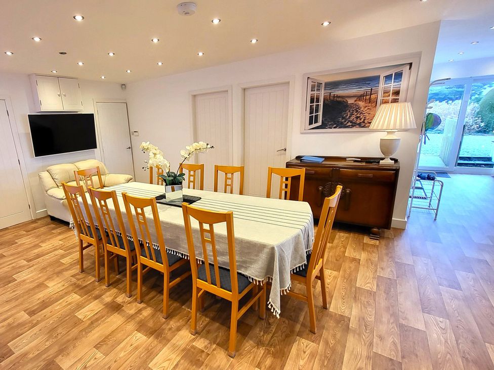 A dining room with a large table and chairs at Top Of The Lane Luxury Holiday Apartment in Benllech