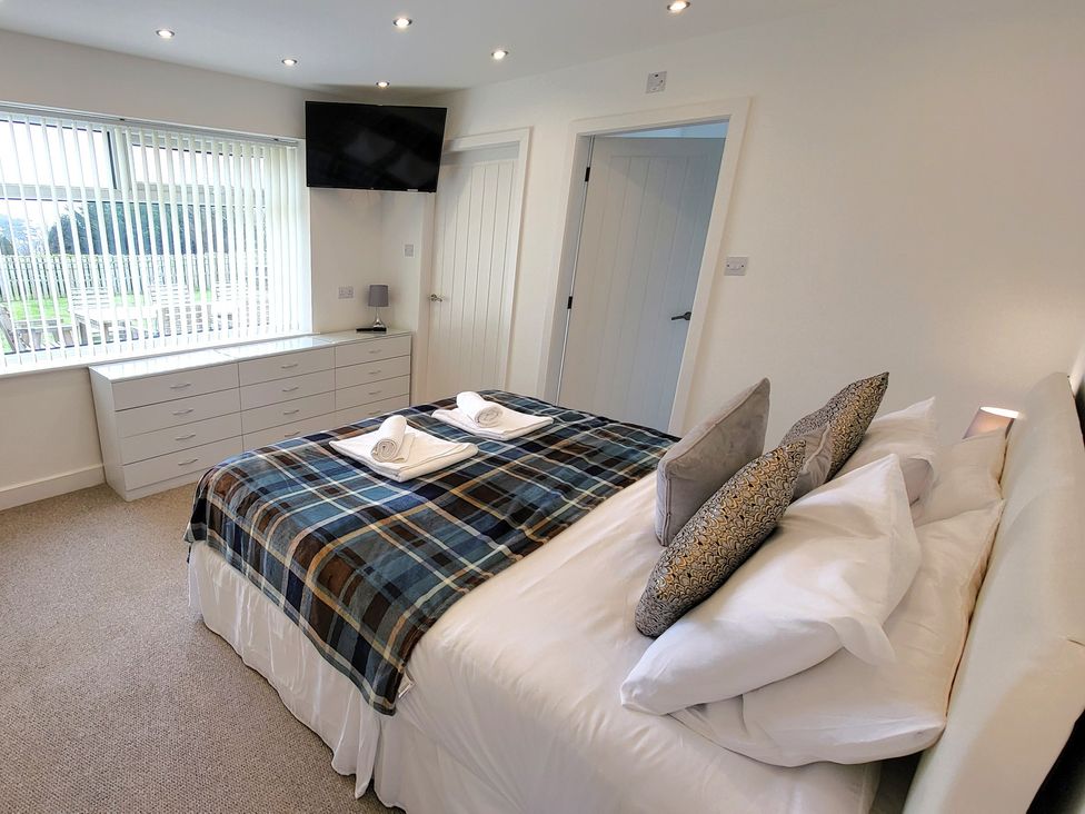 A bedroom with a bed and TV at Top Of The Lane Luxury Holiday Apartment Benllech