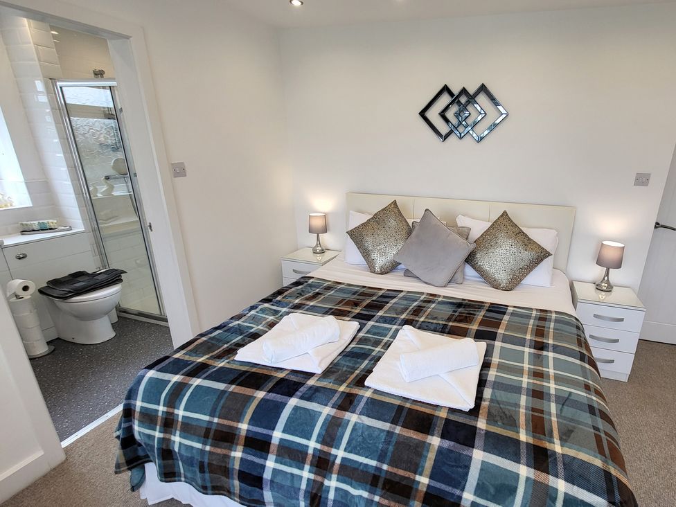 A bedroom with a bed and bathroom visible at Top Of The Lane Luxury Holiday Apartment in Benllech