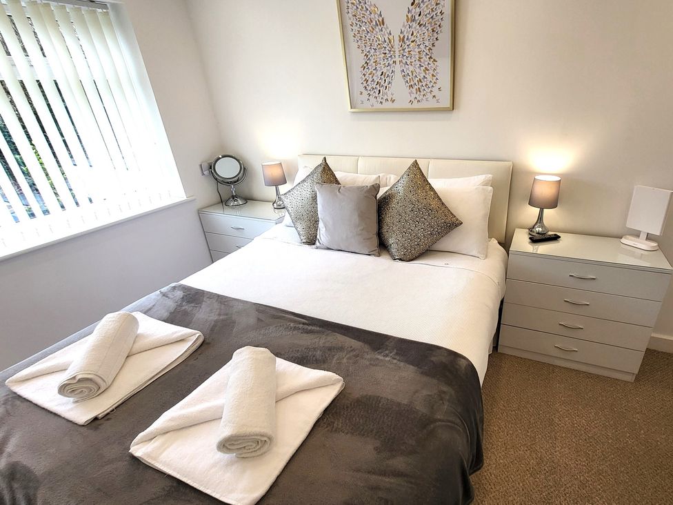 A bedroom with a bed and bedside lamps at Top Of The Lane Luxury Holiday Apartment in Benllech