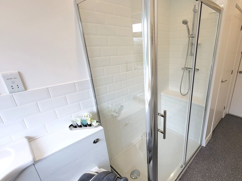A bathroom with a shower, toilet, and sink at Top Of The Lane Luxury Holiday Apartment in Benllech