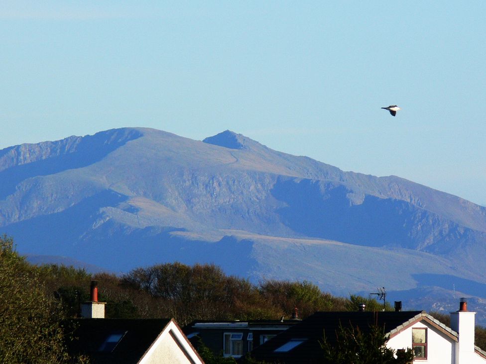 A view of mountains and houses with a bird in flight at Top Of The Lane Luxury Holiday Apartment in Benllech