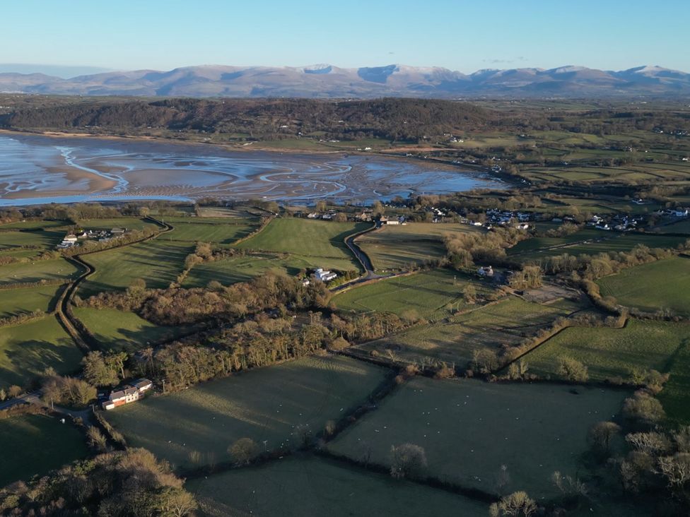 A landscape with fields and houses overlooking a river and mountains at Top Of The Lane Luxury Holiday Apartment Benllech
