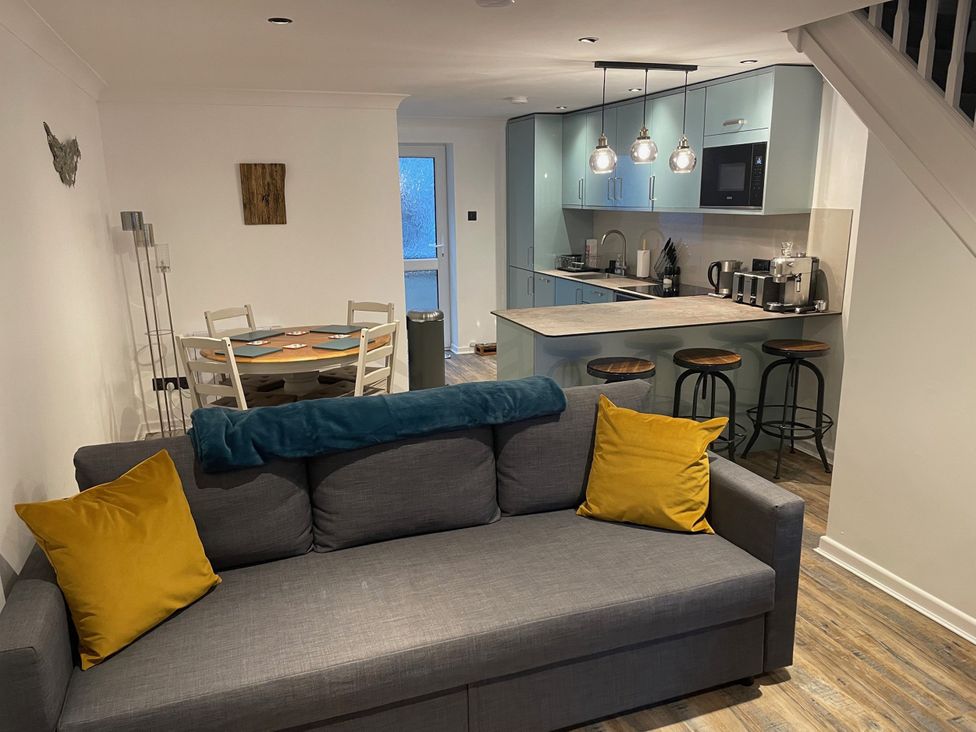 A living room with a sofa and dining area at 51 Fernhill Heights in Charmouth