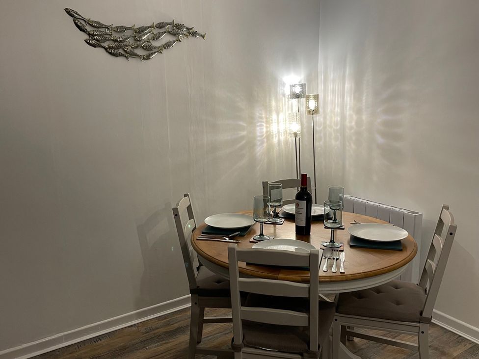 A dining room with a table set for dinner at 51 Fernhill Heights Charmouth