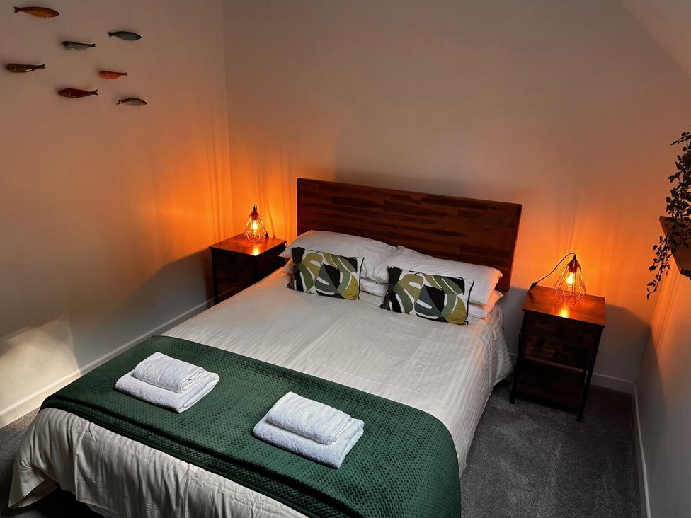 A bedroom with a bed and bedside tables at 51 Fernhill Heights Charmouth