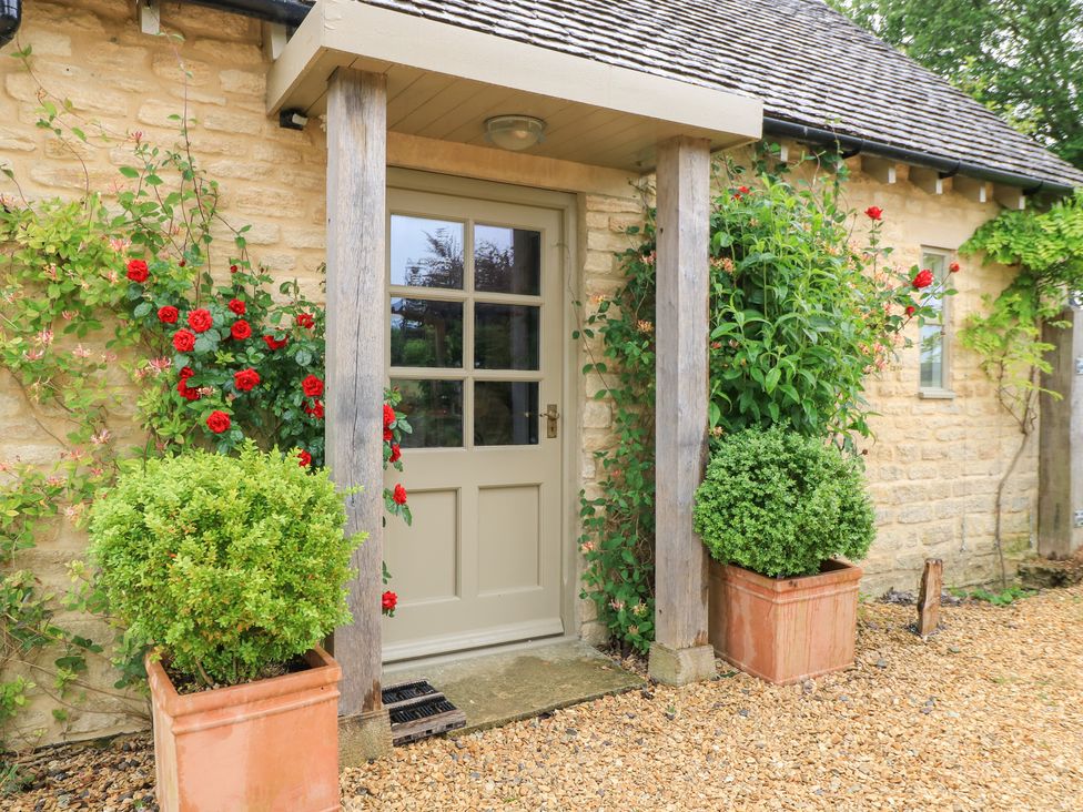 An outdoor entrance with a door and flower planters at Pudding Hill Barn Cottage Bibury