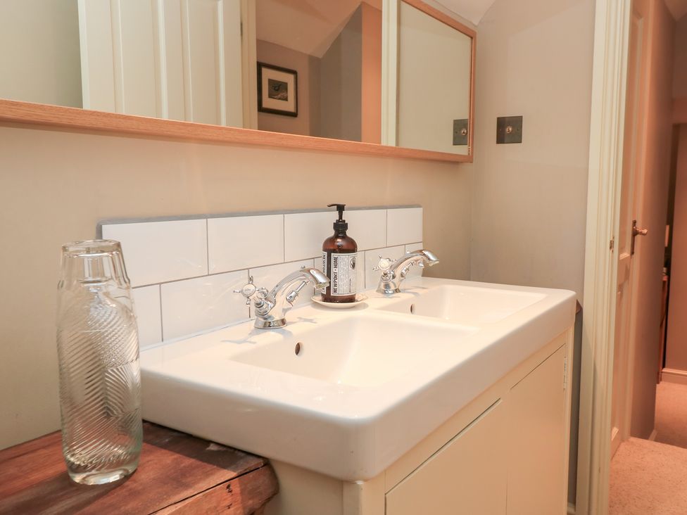 A bathroom with a sink and mirror at Pudding Hill Barn Cottage Bibury