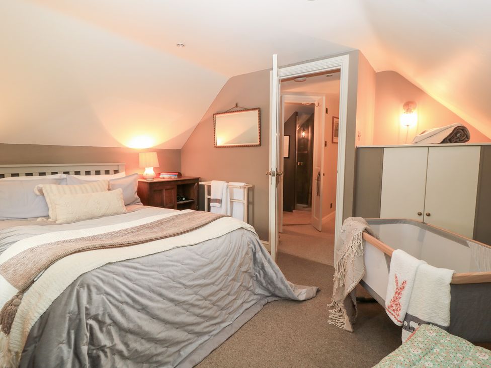A bedroom with a bed and changing table at Pudding Hill Barn Cottage Bibury