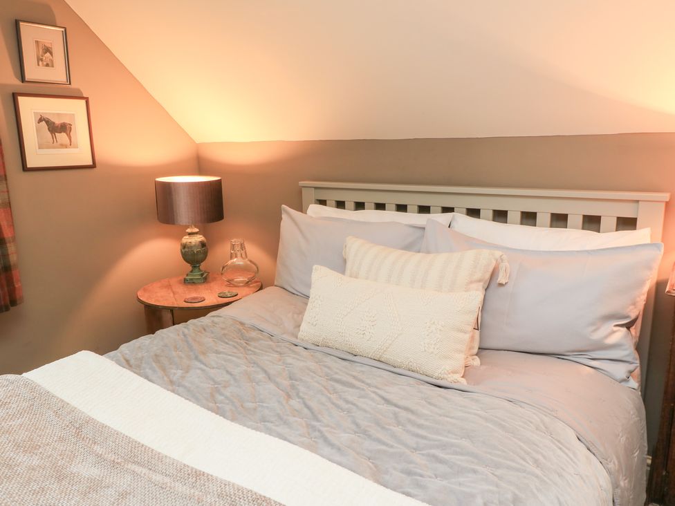A bedroom with a bed and lamp at Pudding Hill Barn Cottage in Bibury